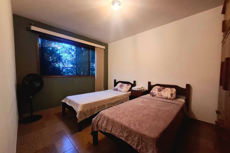 Room with two single beds and a fan