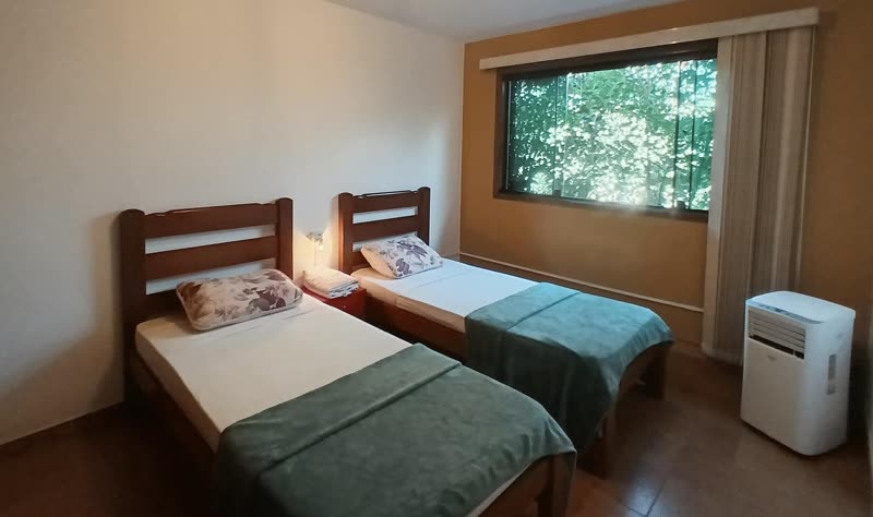 Room with two single beds and a portable air conditioner